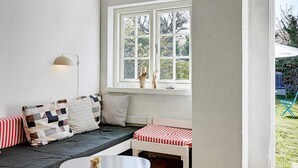 A cozy seating area with a sofa, a bench, and a small table. - Vintage Holiday Home in Svaneke near Small Harbor (Svaneke)