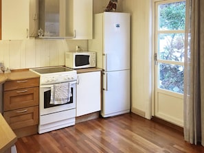 A compact kitchen with a stove, microwave, and refrigerator. - 4 Star Holiday Home in Hovag (Lillesand)