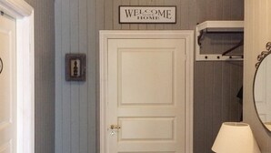 Eine weiße, geschlossene Tür mit einem Schild, auf dem 'WELCOME TO OUR HOME' steht.