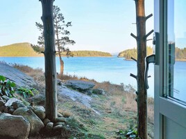 Vista de un lago con un muelle de madera y un muro de piedra.