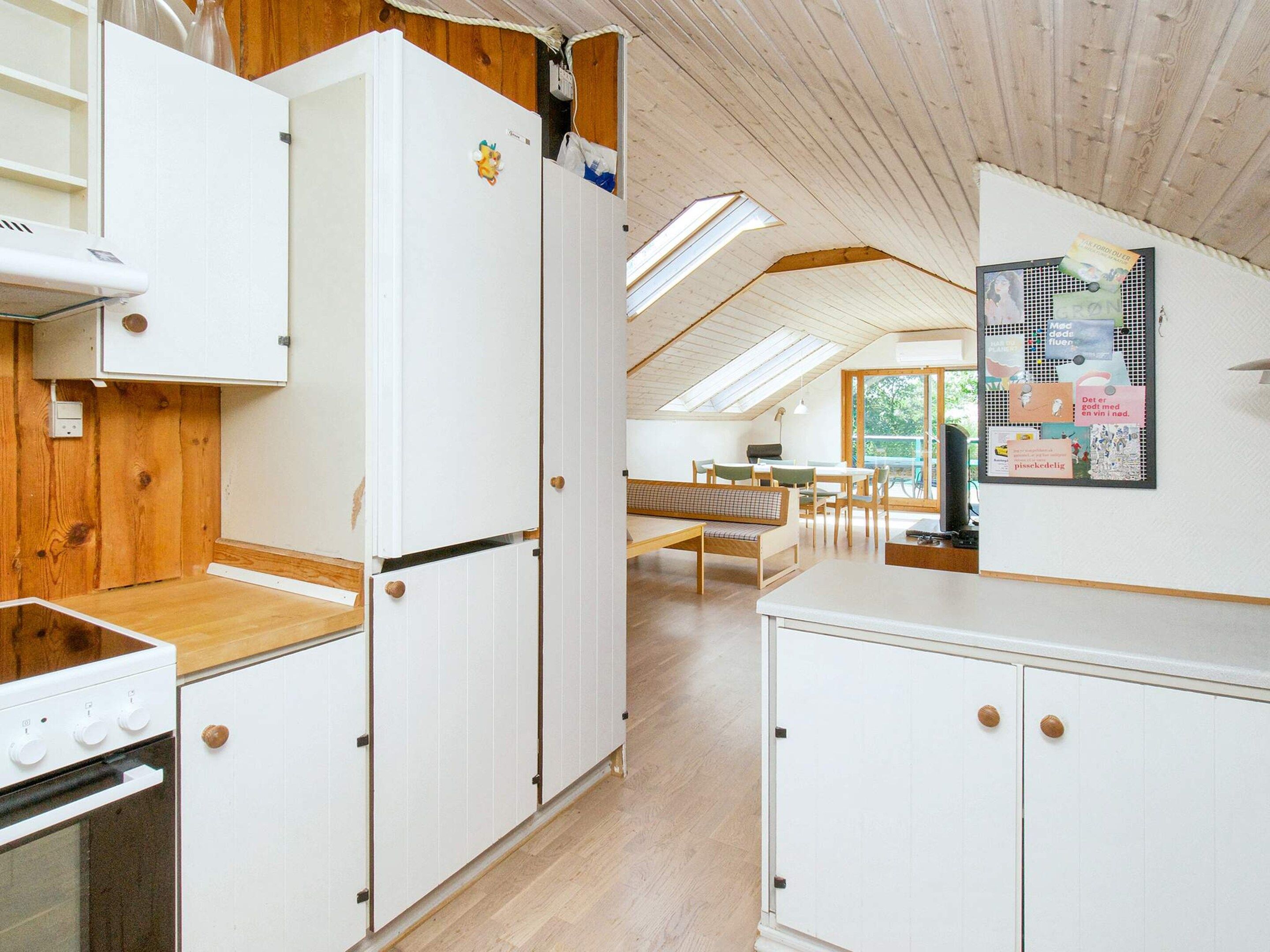 A kitchen with white cabinets, a wooden countertop, and a skylight.