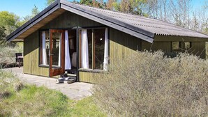 A rustic cabin with a wooden exterior, a sloped roof, and a small porch with steps leading to a door. - Vintage Holiday Home in Jutland near Child Friendly Beach (Aalbaek)