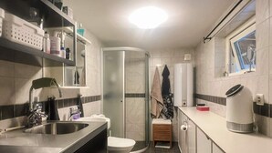 Een kleine keuken met een wastafel, toilet en een klein raam.