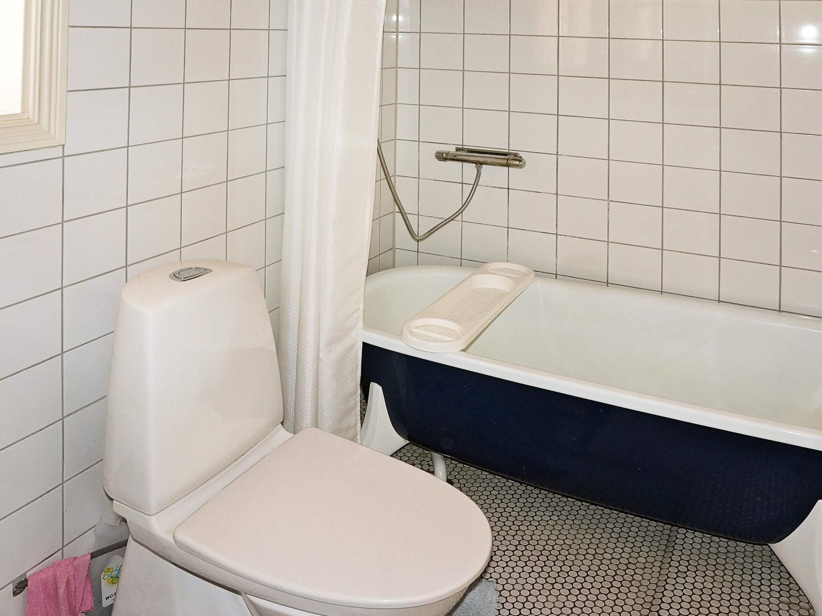 Ein Badezimmer mit Toilette, Badewanne und Dusche.