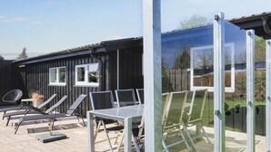 A deck with outdoor furniture, a table, and chairs. - 4 Star Holiday Home in Hals (Hals)