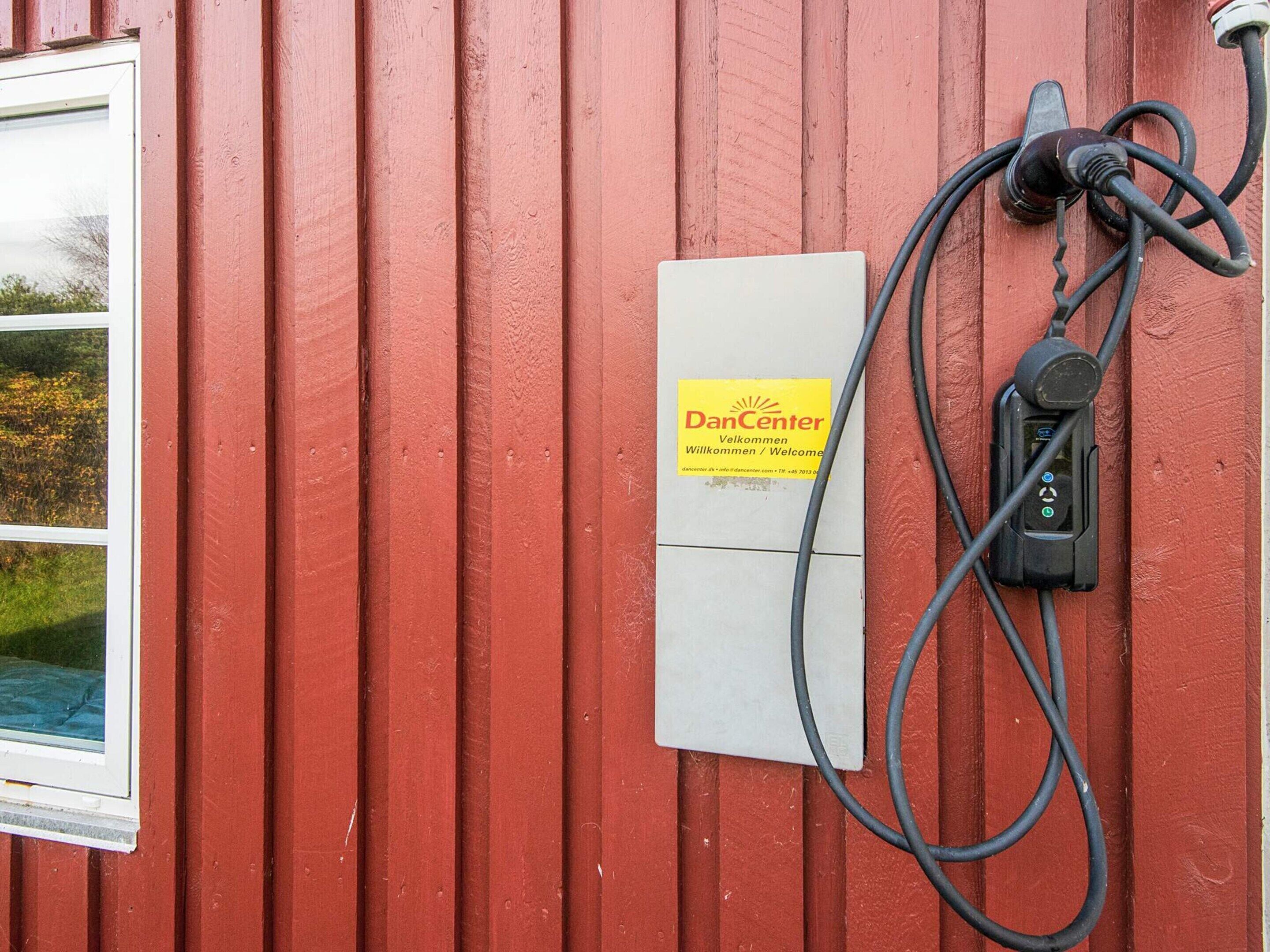 A red building with a DanCenter sign, electrical outlets, and a window.