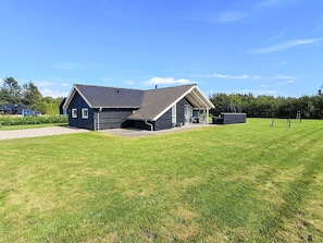 A modern two-story house with a covered porch and a fenced yard.