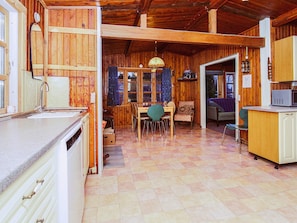Un interior de madera con cocina, comedor y una pequeña sala de estar.