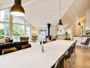 A modern kitchen with a central island, wooden ceiling, and large windows. - 5 Star Holiday Home in Tisvildeleje (Tisvildeleje)