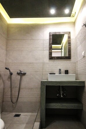 A modern bathroom with a shower, a sink, and a mirror.