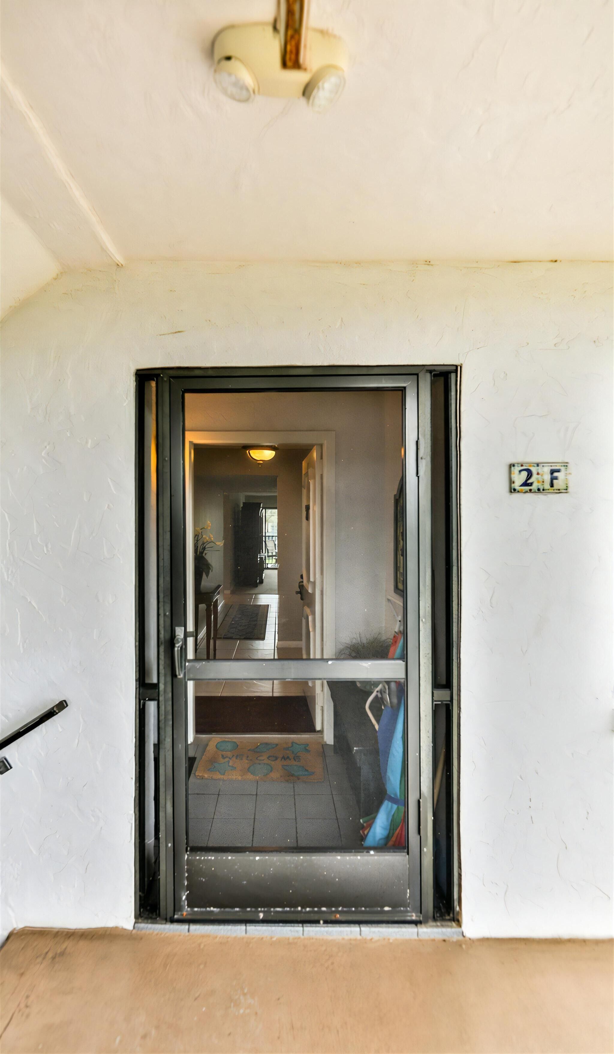 A doorway leading into a room with a doormat that reads "WELCOME".