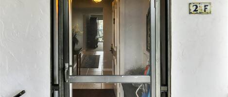 A doorway leading into a room with a doormat that reads "WELCOME".