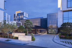 A modern building with a glass facade, surrounded by well-maintained landscaping and a paved walkway. - Park Hyatt Suzhou (Suzhou)