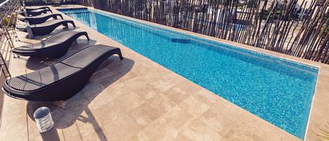 حمّام سباحة خارجي، مظلات على حمّام السباحة، مقاعد للتشمس