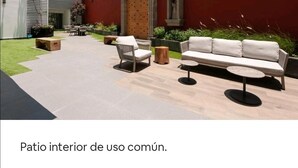 An interior courtyard with a sofa, chairs, and a table. - San Angel - UNAM Beautiful Apartment - 2 parking/3BR/2BA (Ciudad de México)