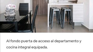 A modern kitchen with a microwave, stove, and bar stools. - San Angel - UNAM Beautiful Apartment - 2 parking/3BR/2BA (Ciudad de México)