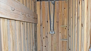 Interno in legno con accessori per doccia in metallo e una mensola in legno.