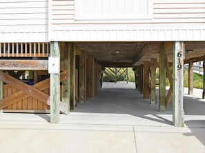 A covered walkway leading to a building with a security sign and a number 619 sign.