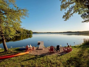 A lakeside setting with a dock, chairs, and a canoe. - Holbrook Retreat - 5 bedroom on 47 acres (Detroit Lakes)