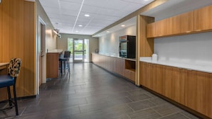 A modern kitchen with wooden cabinets, a refrigerator, and a countertop. - Microtel Inn & Suites by Wyndham Amsterdam (Amsterdam)
