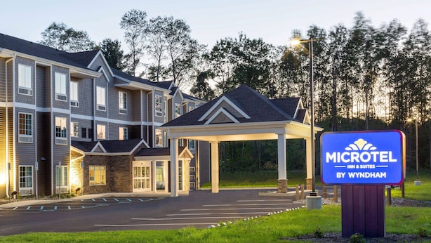 A Microtel Inn & Suites by Wyndham with a covered entrance and a parking lot. - Microtel Inn & Suites by Wyndham Amsterdam (Amsterdam)