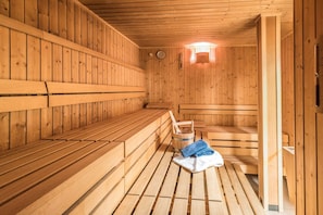 A wooden sauna with benches and a bucket. - D1 Classic apartment***, 54sqm, terrace, swimming pool and sauna access (Oberaudorf)