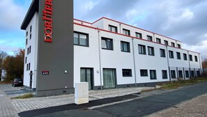 Un moderno edificio de hotel con un llamativo letrero que dice 'DORUMERO' en el lateral.