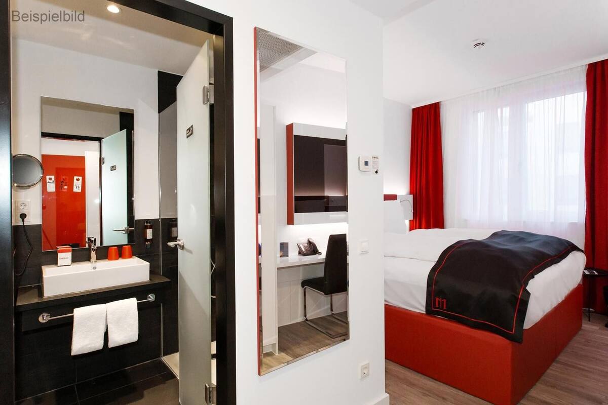 Ein Hotelzimmer mit Bad, Schreibtisch und Bett.