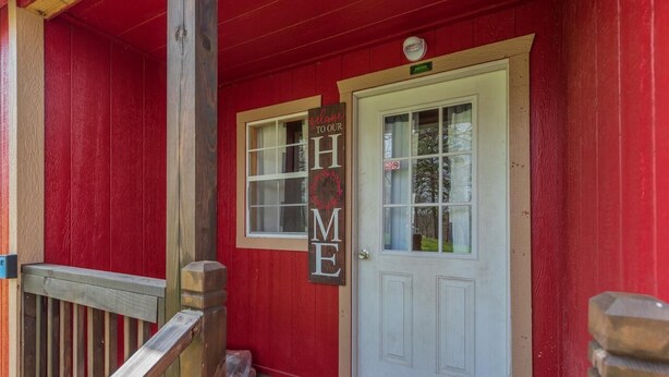 A red building with a white door and a welcome sign. - Tiny House close to Buffalo Point (Saint Joe)