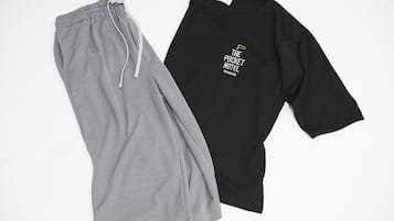 A pair of grey and black clothing items, one with a drawstring and the other with a graphic design.