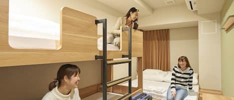 Habitación con literas, una maleta y una mesita.