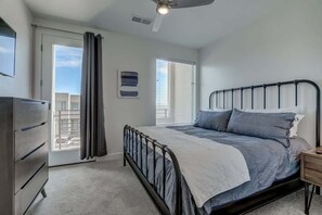 A bedroom with a bed, a dresser, a ceiling fan, and a window with blinds. - The Lofts #38 | Townhome Pool Resort (Saint George)