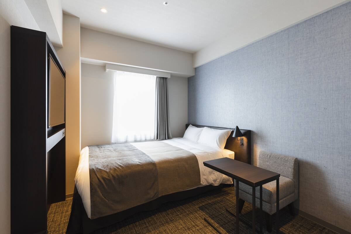 Ein Hotelzimmer mit einem Bett, einem Schreibtisch und einem Sessel.