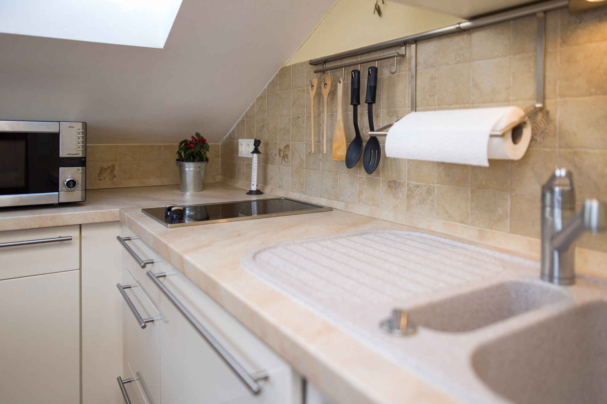 A modern kitchen with a built-in microwave, a sink, and a countertop.