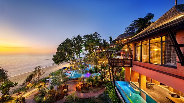 A resort with a pool, outdoor seating, and a view of the beach at sunset. - Nirvana  Beach Resort (Ko Lanta)