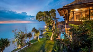 A beachfront property with a large window overlooking the sea, a swimming pool, and a well-maintained garden. - Nirvana  Beach Resort (Ko Lanta)
