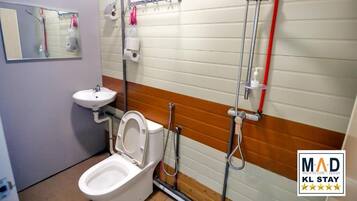 A men's restroom with a toilet, sink, and shower.