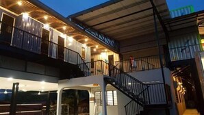 A multi-story building with balconies and a covered walkway.