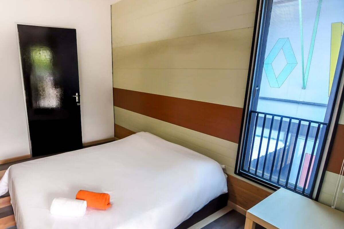 Ein Hotelzimmer mit Bett, Schreibtisch und Fenster mit Blick.