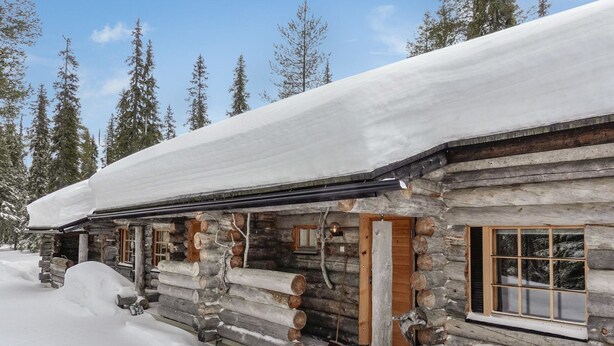 A log cabin with a snow-covered roof, wooden windows, and a porch area. - Aihkelo by Interhome (Sodankylä)