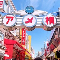 Une rue animée en milieu urbain, avec des panneaux indicateurs et une horloge.