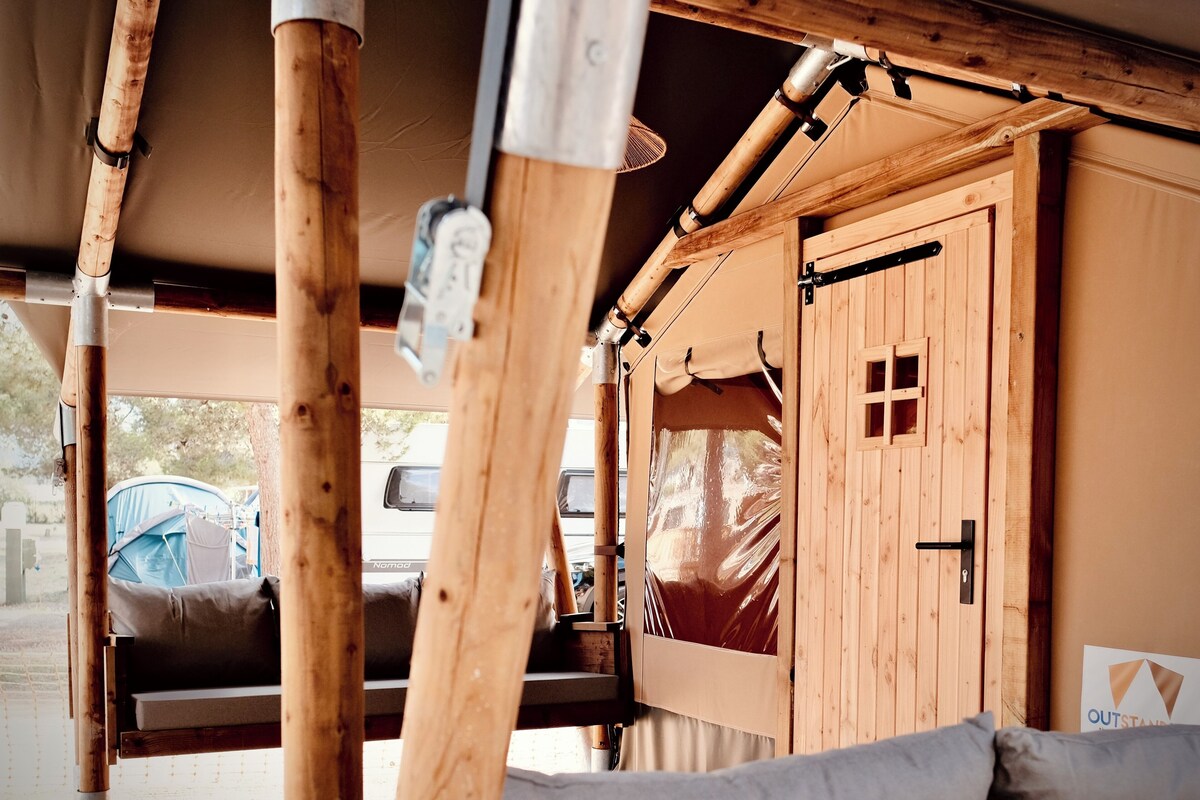 A wooden interior with a bed, a door, and a window.
