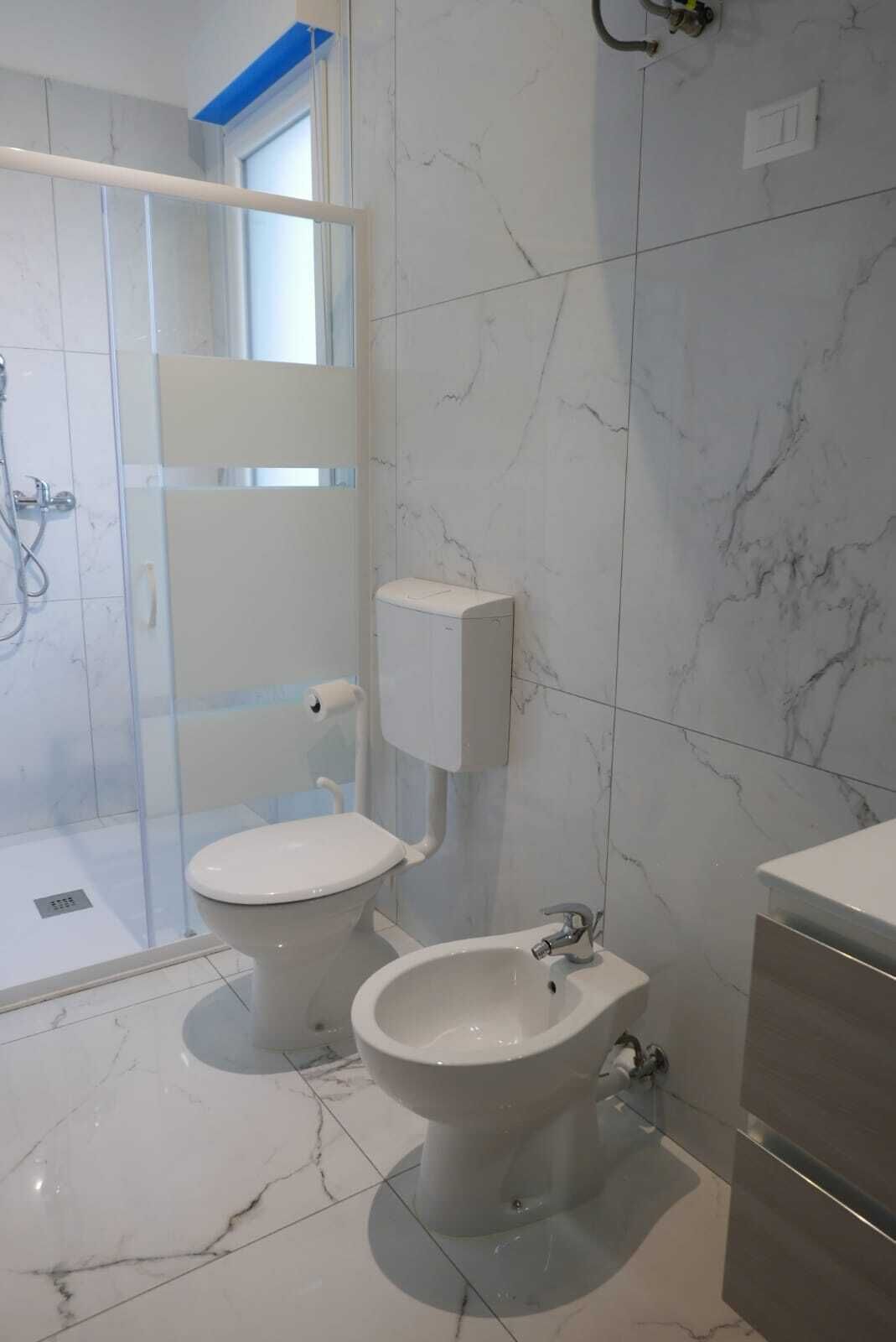 Ein Badezimmer mit Toilette, Bidet und Duschbereich.