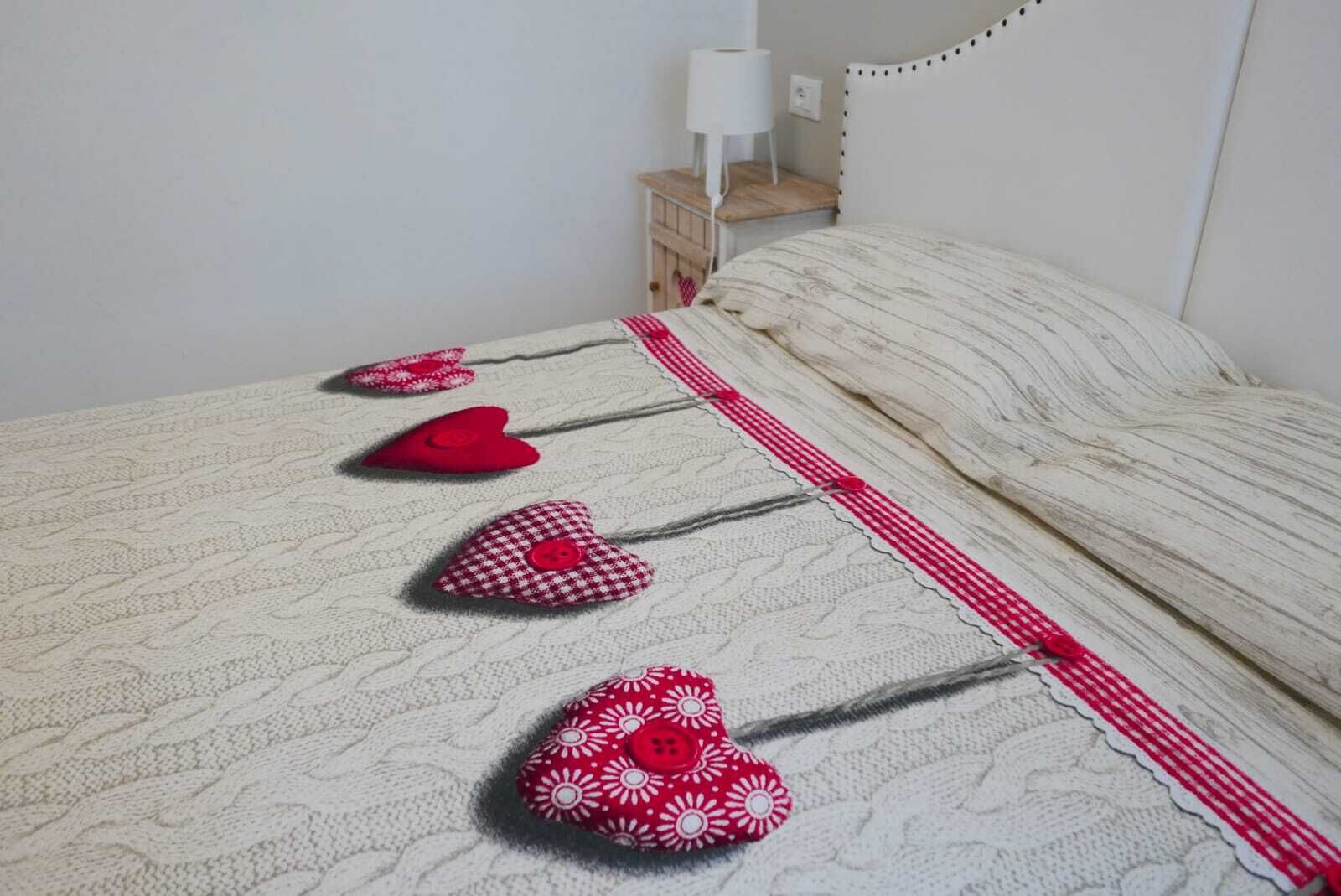 Ein Bett mit weißer Decke und einem Kissenbezug in Rot und Weiß gestreift.