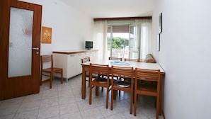 A compact kitchen with a dining area, a TV, and a view of the outdoors.