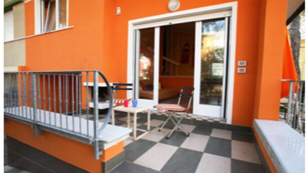 A balcony with a checkered floor, a table, and a chair. - Villa Polluce (San Michele al Tagliamento)