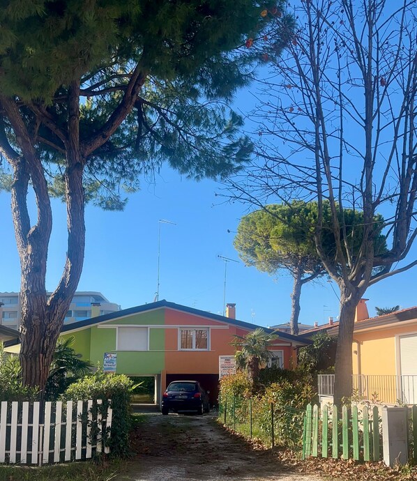 A residential street with houses, a car in a driveway, and a clear blue sky. - Villa Polluce (San Michele al Tagliamento)