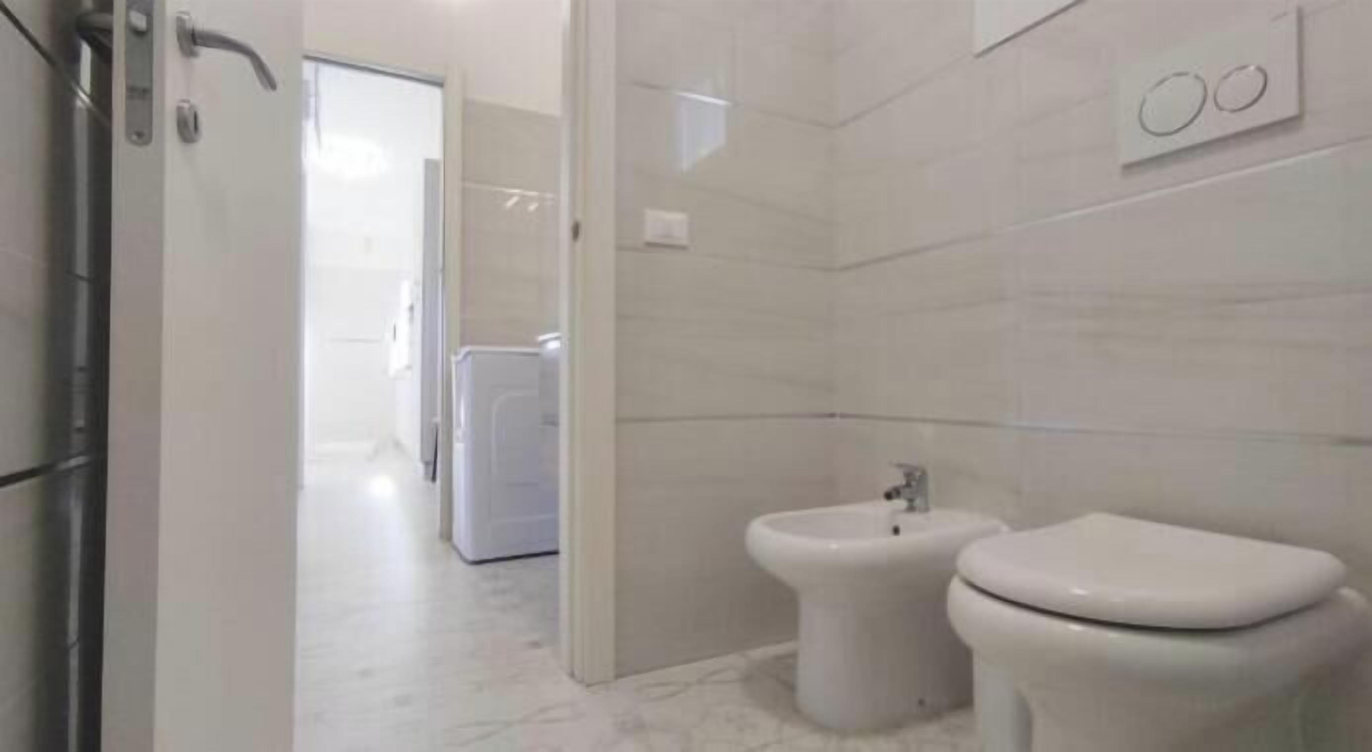 A modern bathroom with a toilet, bidet, and a shower area.