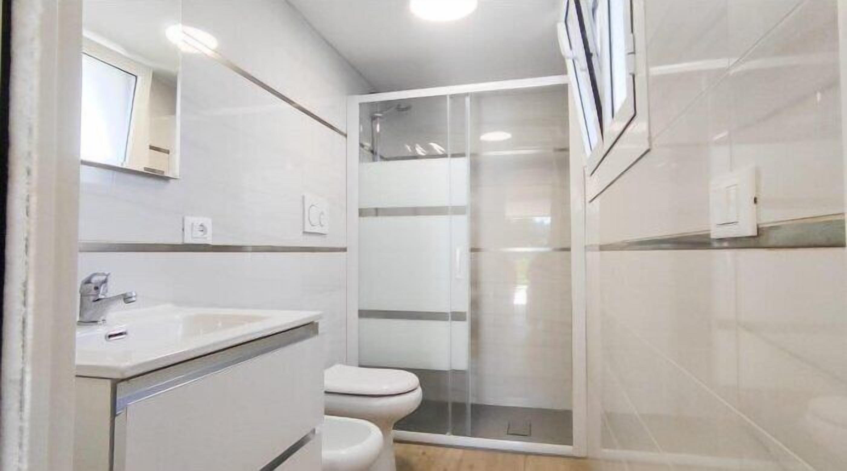 Ein kleines Badezimmer mit Waschbecken, Toilette und einer Duschkabine.