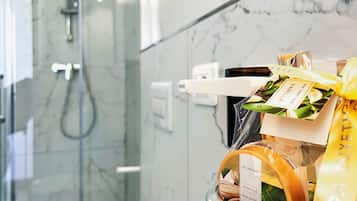 Une salle de bain dotée d’une douche à parois de verre et d’un espace coiffeuse avec des articles de toilette.